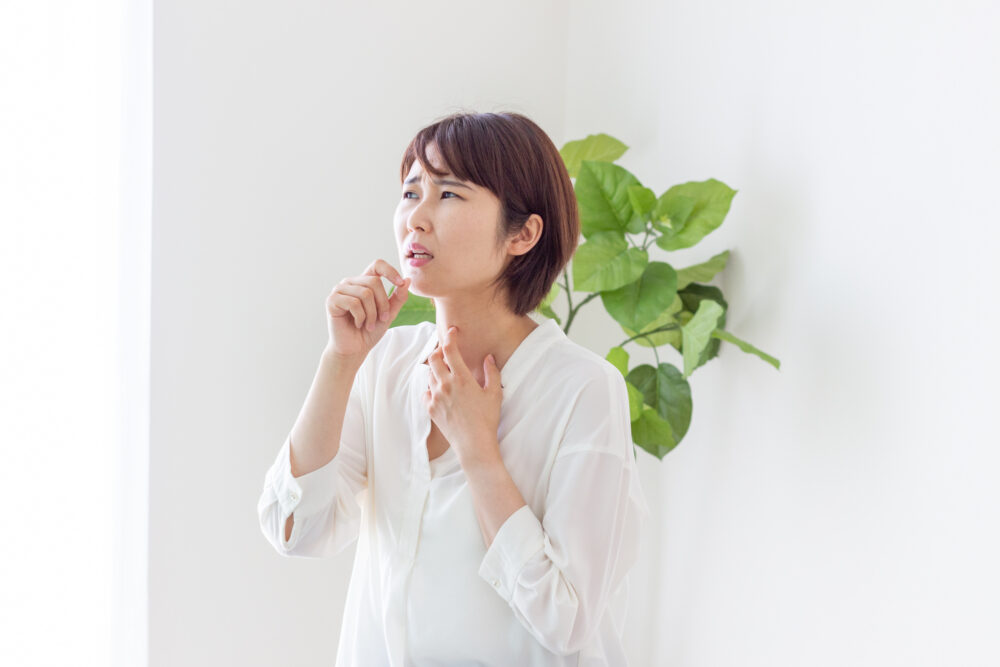 気管支喘息(喘息)で苦しさを感じる女性の画像
