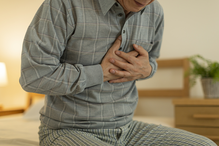 長引く咳による胸の痛みを感じている男性｜呼吸器症状の悪化イメージ