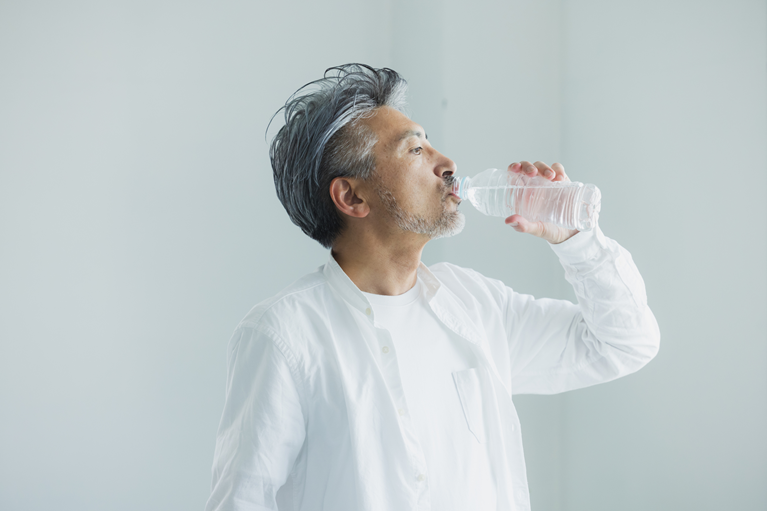 長引く咳の対策として水分補給をしている男性のイメージ